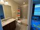Bright bathroom with a combination tub and shower, colorful curtain, and granite vanity at 7609 Brookhurst Ln, Kissimmee, FL 34747