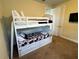 Bright bedroom features white bunk beds, a mounted tv, and neutral walls at 7609 Brookhurst Ln, Kissimmee, FL 34747