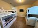 Bright bedroom featuring two sets of white bunk beds and wall-mounted TV at 7609 Brookhurst Ln, Kissimmee, FL 34747