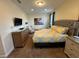 Bedroom with a large bed with tufted headboard and bright bedspread and carpeted floor at 7609 Brookhurst Ln, Kissimmee, FL 34747
