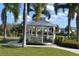 Charming white gazebo provides a relaxing outdoor space amidst the lush landscaping of this welcoming community at 7609 Brookhurst Ln, Kissimmee, FL 34747
