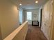 Upstairs hallway featuring neutral paint, carpet, and a window for natural lighting at 7609 Brookhurst Ln, Kissimmee, FL 34747