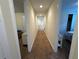 Hallway featuring brown carpet and doors leading to the rooms at 7609 Brookhurst Ln, Kissimmee, FL 34747