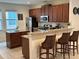 Cozy kitchen featuring dark wood cabinets, stainless steel appliances, and a breakfast bar at 7609 Brookhurst Ln, Kissimmee, FL 34747