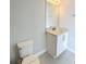 Cozy bathroom featuring a vanity with a granite countertop, tiled floors, a wall mirror, and modern fixtures at 7719 Graben St, Kissimmee, FL 34747