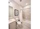 Well-lit bathroom features a shower-over-tub, a framed inspirational sign and tiled walls for a clean and modern design at 7719 Graben St, Kissimmee, FL 34747