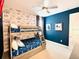 Fun ' bedroom featuring a bunk bed, Star Wars wallpaper, a ceiling fan, and a dark blue accent wall at 7719 Graben St, Kissimmee, FL 34747