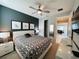 Modern bedroom with a queen bed, dark accent wall, geometric bedding, and an open doorway leading to the living area at 7719 Graben St, Kissimmee, FL 34747