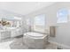 Bright bathroom with a large soaking tub, white cabinets, and luxury finishes at 8025 Topsail Pl, Winter Garden, FL 34787