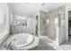 Gorgeous primary bathroom featuring dual vanities, soaking tub, and glass-enclosed shower with designer tile at 8025 Topsail Pl, Winter Garden, FL 34787