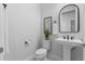 Elegant powder room featuring a modern pedestal sink, sleek fixtures, and stylish decor at 8025 Topsail Pl, Winter Garden, FL 34787
