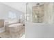 Beautiful primary bathroom featuring a soaking tub with picture window and a large glass shower at 8025 Topsail Pl, Winter Garden, FL 34787