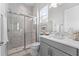 Modern bathroom featuring marble shower, glass door, and gray vanity at 8025 Topsail Pl, Winter Garden, FL 34787