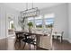 Charming dining room with a modern light fixture and views of the lush backyard at 8025 Topsail Pl, Winter Garden, FL 34787