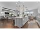 Open kitchen features an island with sink and seating, seamlessly connecting to the living area at 8025 Topsail Pl, Winter Garden, FL 34787
