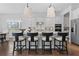 Modern kitchen with white cabinets, a central island with bar stools, and stainless steel appliances at 8025 Topsail Pl, Winter Garden, FL 34787
