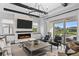 Modern living room with a fireplace, neutral decor, ample seating, and sliding glass doors at 8025 Topsail Pl, Winter Garden, FL 34787
