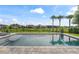 Relaxing pool area overlooking a lush green lawn, fenced for privacy, and featuring tranquil water views at 8025 Topsail Pl, Winter Garden, FL 34787