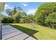 Large backyard with lawn, stone pavers and trees at 824 Palm Cove Dr, Orlando, FL 32835