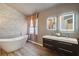 Modern bathroom featuring freestanding tub, double sink vanity with lighted mirrors, and accent wall at 824 Palm Cove Dr, Orlando, FL 32835