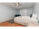 This is a bedroom featuring wood-look floors, a ceiling fan, an accent rug, and a plush blue armchair at 8711 Rockingham Ter # A, Kissimmee, FL 34747