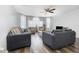 Bright living room with wood floors, plush sofas, armchairs, a ceiling fan, and large windows with sheer curtains at 8711 Rockingham Ter # A, Kissimmee, FL 34747