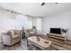 Well-lit living room with hardwood floors, comfortable sofas, a ceiling fan, and large windows with sheer curtains at 8711 Rockingham Ter # A, Kissimmee, FL 34747