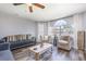 Comfortable living room boasting hardwood floors, ample seating, a ceiling fan, and large windows with sheer curtains at 8711 Rockingham Ter # A, Kissimmee, FL 34747
