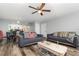 Open-concept living area with wood floors and view of the kitchen, featuring comfortable sofas and a dining set at 8711 Rockingham Ter # A, Kissimmee, FL 34747