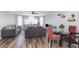 Bright living room with dining area featuring hardwood floors, comfortable seating, large windows, and a ceiling fan at 8711 Rockingham Ter # A, Kissimmee, FL 34747