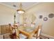 Elegant dining room with a glass top table, decorative mirror, and decorative plate display at 9102 Shadowbrook Trl, Orlando, FL 32825