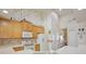 Bright kitchen features light wood cabinets and white appliances under a tall, vaulted ceiling at 9102 Shadowbrook Trl, Orlando, FL 32825