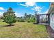 Spacious backyard with a lush green lawn, mature trees, and screened in patio at 937 Avery Meadows Way, Deland, FL 32724