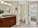 Well-lit bathroom features a granite countertop, dark wood cabinets, and open access to an attached bedroom at 937 Avery Meadows Way, Deland, FL 32724