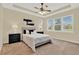Cozy bedroom with neutral carpet and a tray ceiling with ceiling fan at 937 Avery Meadows Way, Deland, FL 32724