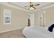 Bedroom with tray ceiling, fan, and a peek into the hallway and bathroom at 937 Avery Meadows Way, Deland, FL 32724