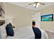 Nicely decorated bedroom with ceiling fan, TV, and comfortable-looking bed with blue pillows at 937 Avery Meadows Way, Deland, FL 32724