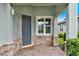 Inviting front porch featuring a brick paver floor, stone accents, and a stylish front door at 937 Avery Meadows Way, Deland, FL 32724