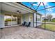 Spacious screened patio with brick flooring, ceiling fan, and blue lawn chairs at 937 Avery Meadows Way, Deland, FL 32724
