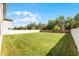 Huge backyard with lush green grass and white vinyl fence, offering privacy and space for outdoor activities at 965 Talon Pl, Winter Springs, FL 32708
