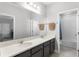 Bright bathroom featuring dual sinks, a large mirror, and access to another bathroom at 965 Talon Pl, Winter Springs, FL 32708