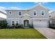 Charming two-story home featuring a well-maintained lawn and a two car garage with a brick paver driveway at 965 Talon Pl, Winter Springs, FL 32708