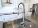 Modern kitchen sink with stainless steel faucet and fixtures, complemented by sleek countertops and cabinetry at 965 Talon Pl, Winter Springs, FL 32708