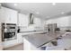 Modern kitchen with stainless steel appliances, white cabinets, and a large center island at 965 Talon Pl, Winter Springs, FL 32708