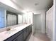 Spacious bathroom with double vanity, gray cabinets, large mirrors, and a separate shower area at 9787 Introduction Way, Orlando, FL 32832