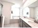 Bright bathroom with double sinks, modern gray cabinetry, and a luxurious soaking tub at 9787 Introduction Way, Orlando, FL 32832