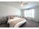 This bedroom features neutral paint, ceiling fan, carpet, window with blinds, and decorative pillows at 9787 Introduction Way, Orlando, FL 32832