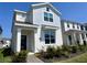 Charming two-story home featuring a blue accent wall, manicured landscaping, and a welcoming covered entryway at 9787 Introduction Way, Orlando, FL 32832