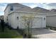 View of the house with a two-car garage and well-maintained landscaping at 9787 Introduction Way, Orlando, FL 32832