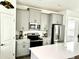 Modern kitchen with gray cabinets, stainless steel appliances, and a large quartz island at 9787 Introduction Way, Orlando, FL 32832